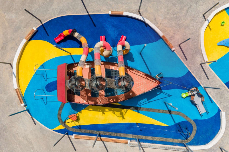 Colorful poured-in-place rubber playground surfacing with themed play structure, installed by NJ Swingsets and Playgrounds