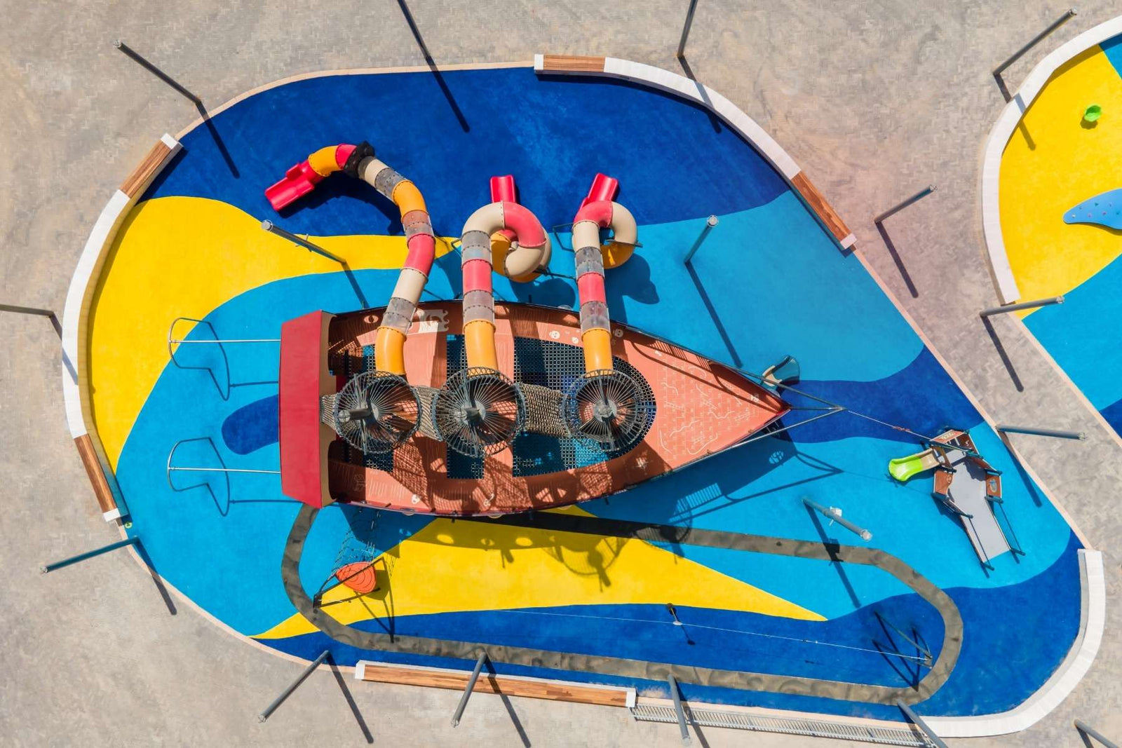 Colorful poured-in-place rubber playground surfacing with themed play structure, installed by NJ Swingsets and Playgrounds
