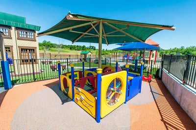 Superior Shade single-post hexagon umbrella over a playground